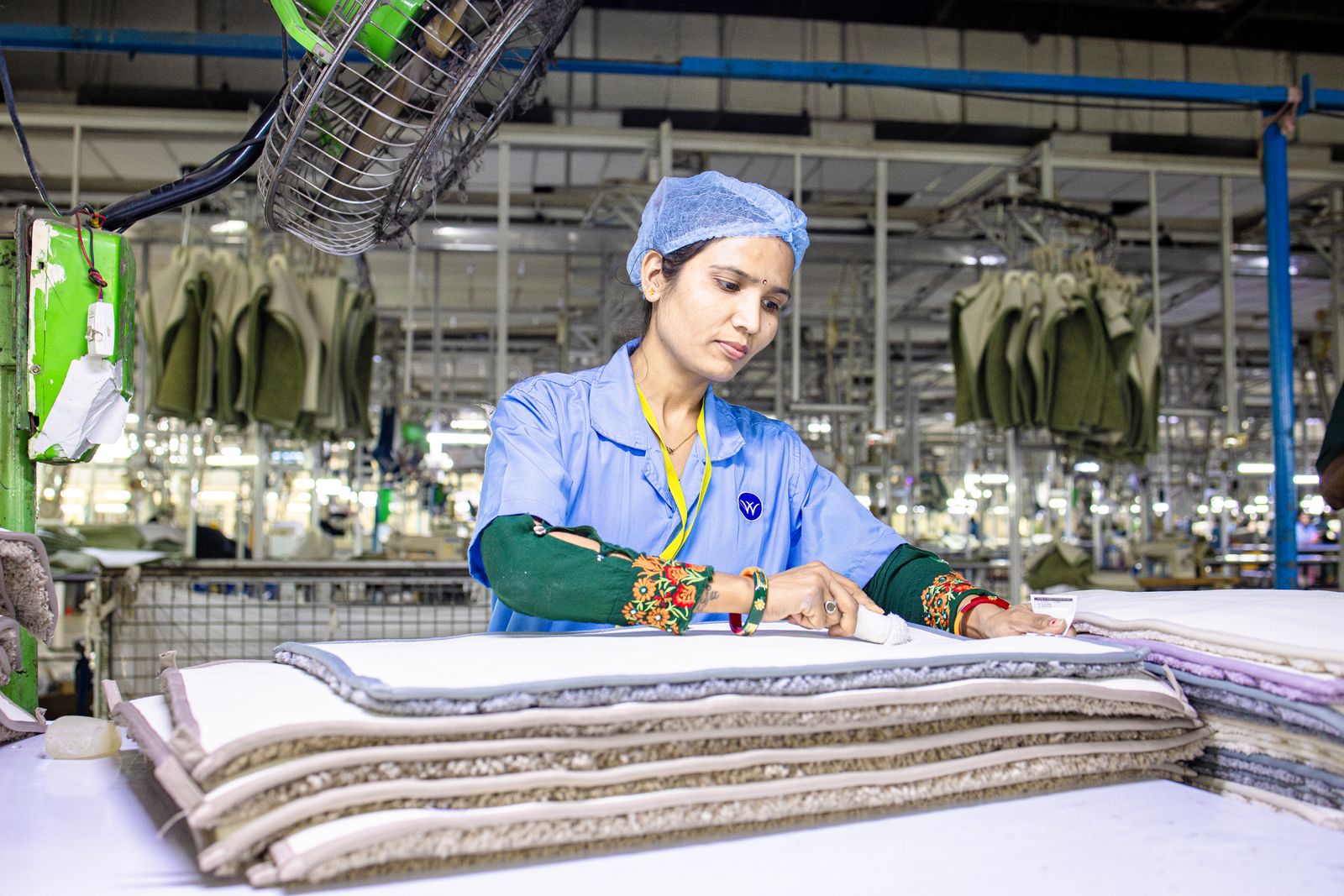 Worker inspecting textile layers at a factory quality checkpoint